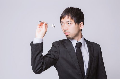 ダーツの矢を構えるスーツ姿のビジネスマン