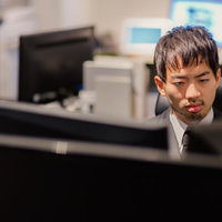 オフィスでモニターを見つめる男性スタッフの写真