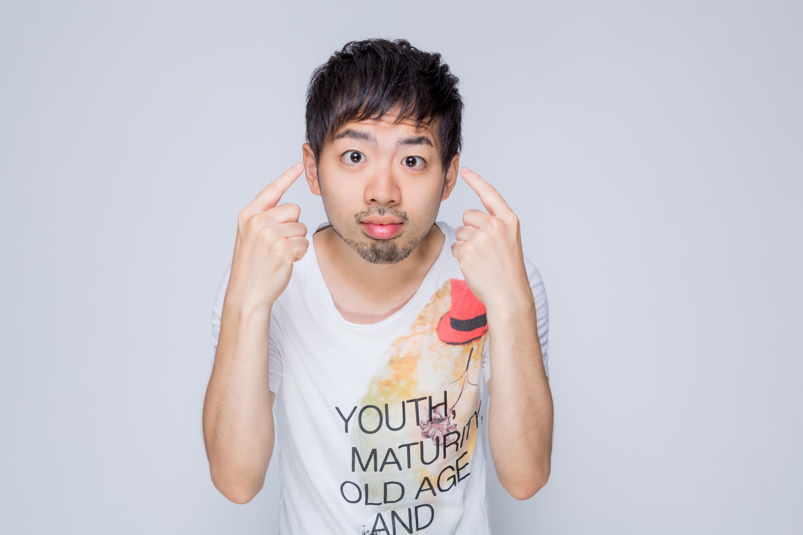 両手で顔を指しながら目を見つめる男性が驚いた表情で視線を促している［モデル：ひろゆき］