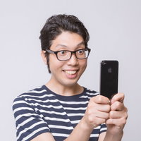 スマートフォンで撮影する眼鏡の男性の写真