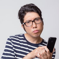 アプリの使い方がわからなくて困惑する男性の写真