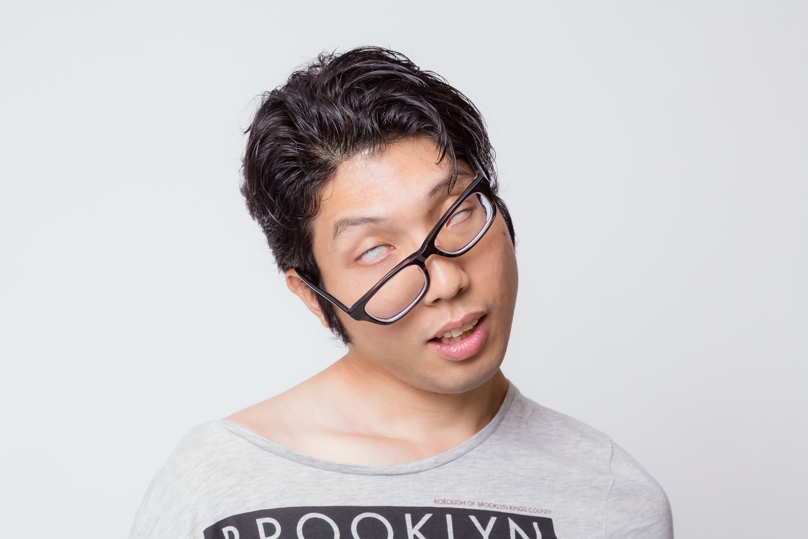 眼鏡をかけて白目を向き、困り果てた表情の男性［モデル：紳さん］