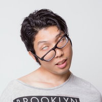 疲れた表情で首を傾ける眼鏡の男性の写真