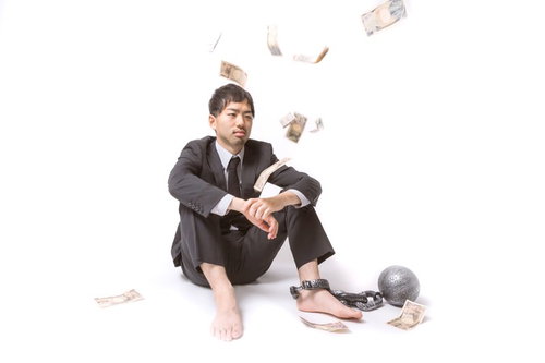 鉄球につながれ降ってくるお金を見つめる社畜