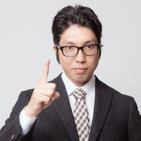 人差し指を立てて「ナンバーワン」ポーズのビジネスマンの写真