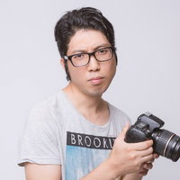 一眼レフカメラを構える男性の写真