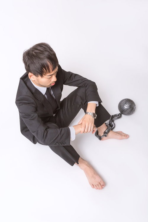 足枷と鉄球につながれた会社員