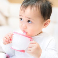 ジュースを飲むと上機嫌の赤ちゃんの写真