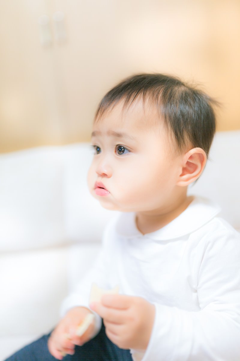 室内で座り左を向く幼児の横顔［モデル：Lisa］