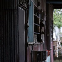 窓や外壁が傷んだボロボロのアパートの写真