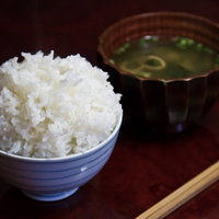 ちゃぶ台の上のてんこ盛り白米とみそ汁の写真