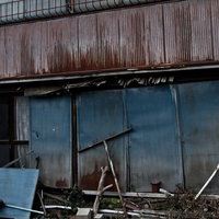 壁が崩れ始めた朽ちたアパートの外観の写真