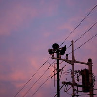 不気味な雲が広がる禍々しい空とサイレンの鉄塔の写真