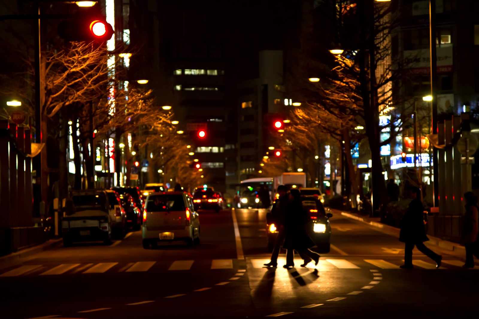 夜の横断歩道を渡る人々