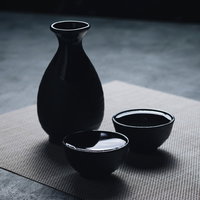 黒い徳利から白いお猪口になみなみと注がれた日本酒の写真