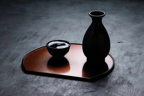 逆光で黒くシルエットになった徳利とお猪口