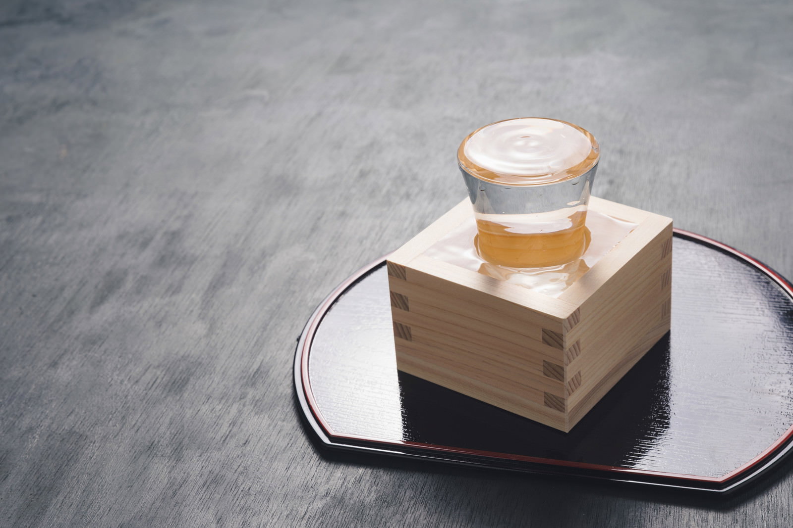 木製の升に表面張力で盛り上がるほど注がれた日本酒のもっきり