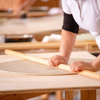 武石観光センターで生地を伸ばす蕎麦打ち職人の写真