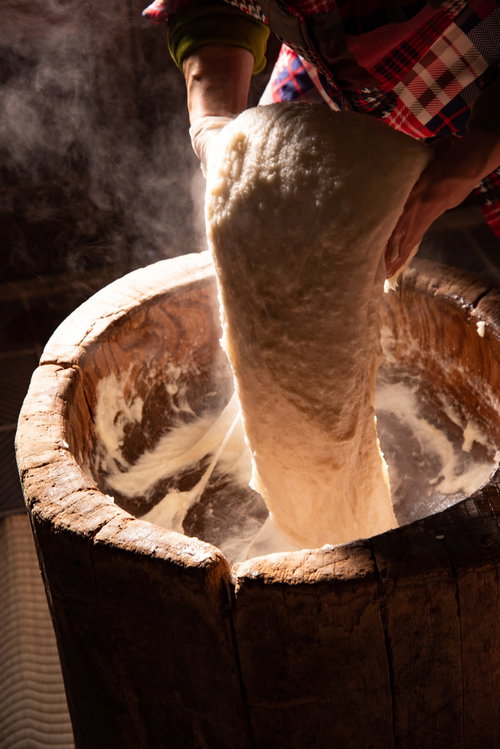 つきたての餅を持ち上げる返し手の手つきと杵の動き