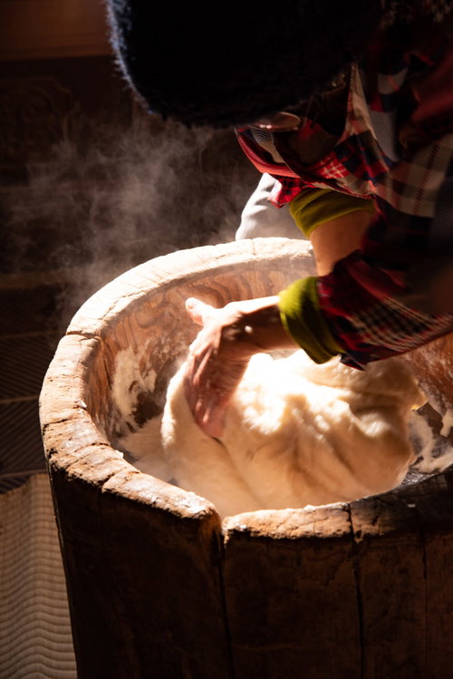 湯気が立ち上る臼で餅を回すベテランの手つき技