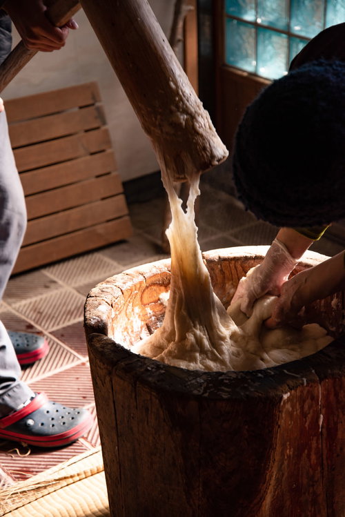 杵について伸びる餅つきの餅と湯気