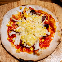 釜から上がったばかりのチーズたっぷりのピザの写真