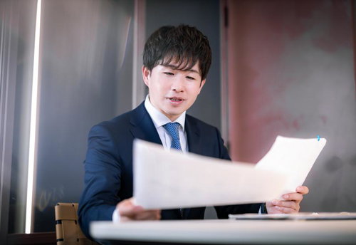 財務資料に目を通すM&Aアドバイザーの男性