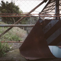 錆びて朽ち果てた進入禁止の門扉と廃墟の風景の写真