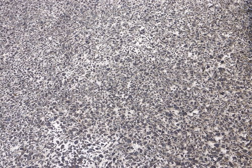 小さな石や砂利が混じり穴がある屋外のコンクリート床のテクスチャー