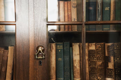 古い洋書と真鍮の取っ手が付いた木製本棚