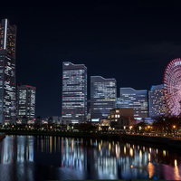 観覧車とビル群の灯りが水面に映る横浜の夜景の写真