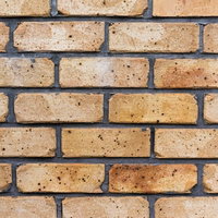 黒い穴や斑点が見える茶色いレンガが積まれた壁のテクスチャーの写真