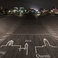 夜間の大さん橋に描かれた横浜三塔の絵柄と夜景の写真