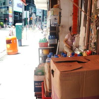 段ボール箱とペットボトルが並ぶ香港の路上店舗の写真