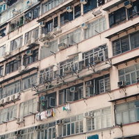エアコン室外機と洗濯物が並ぶ香港の集合住宅の写真