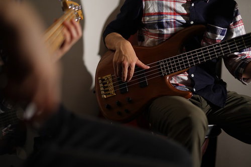 エレキベースを指弾きする演奏者の手元とフォーム