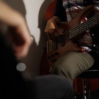 ベースを弾くふたりのセッション演奏、指弾きで奏でる弦楽器の音色の写真