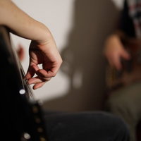 指弾きでベースを演奏するベーシストの手元の写真