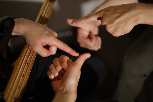 スラップ奏法での親指の位置を確認中のベーシスト