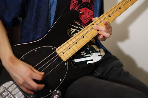 メイプルネックのエレキベースを弾くバンドマンの手元