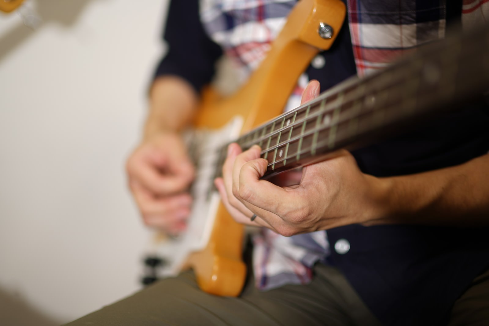 ベースを弾く手元、弦を押さえる指とピックアップが写っている