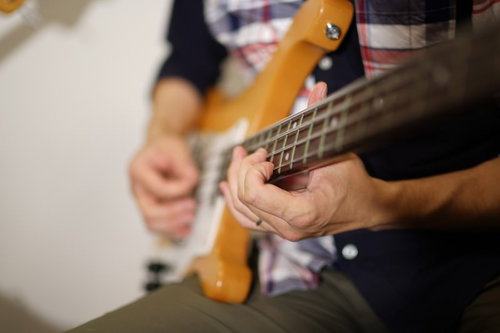 ベースを弾くプロの手元、弦を押さえる指とピックアップ