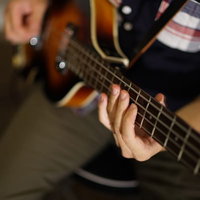 プロベーシストの演奏風景 ベース弦楽器の手元ネック部分クローズアップの写真