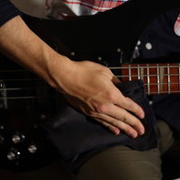 弦専用のクロスで拭くベースのメンテナンスの写真