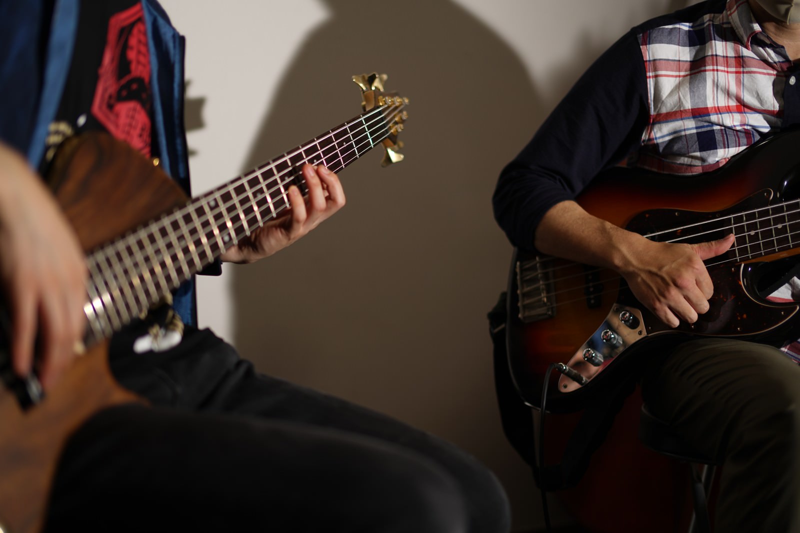 ベーシストが座ってベースを演奏している音楽セッションの様子