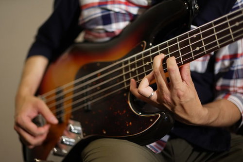 難しいハイポジションを押さえて演奏するベーシスト
