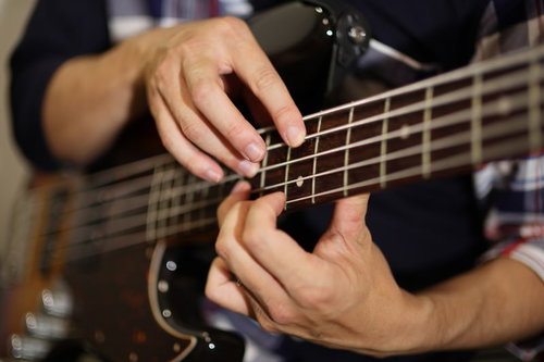 5弦ベースでタッピング奏法を演奏するベーシスト
