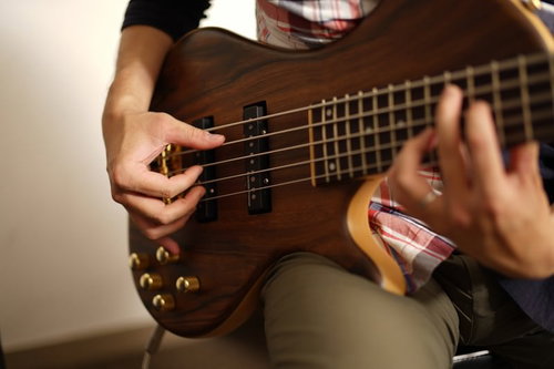 ハイポジションを押さえるベーシストの演奏