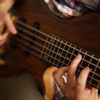 指弾きするベーシストの弦さばきと手元の動きの写真