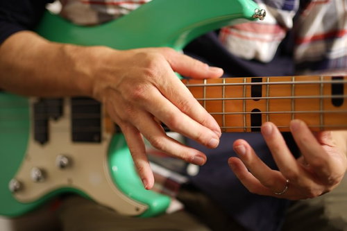 エレキベースのフレットボードをタッピング演奏する手元